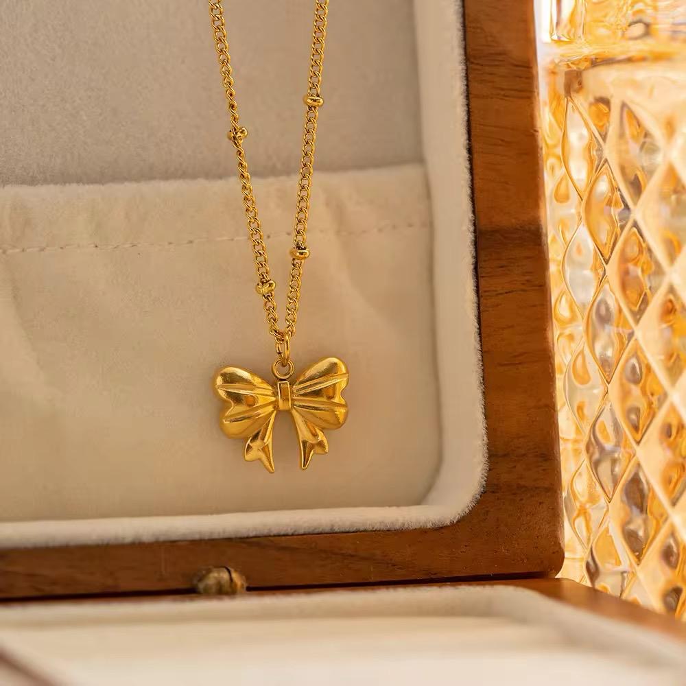 Gold bowknot necklace featuring a delicate ribbon design made from anti-tarnish stainless steel, perfect for gifting