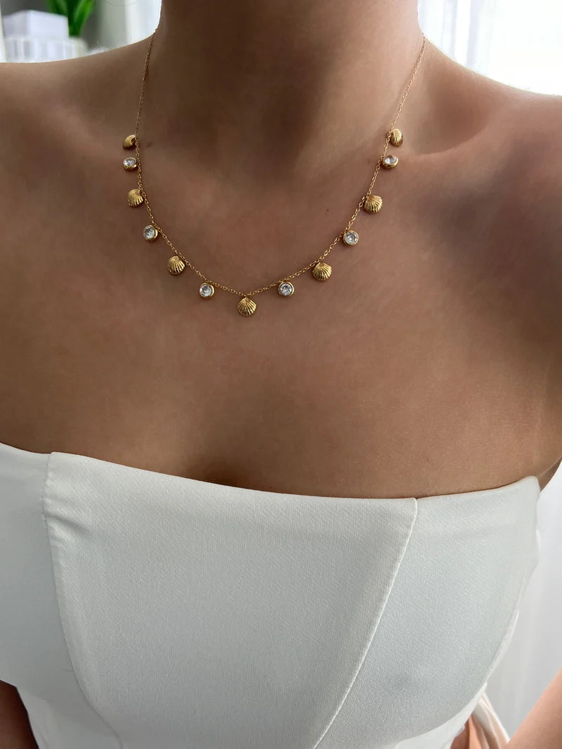 Beach-inspired shell charm necklace with gold plating and crystals, ideal for resort wear or gifting