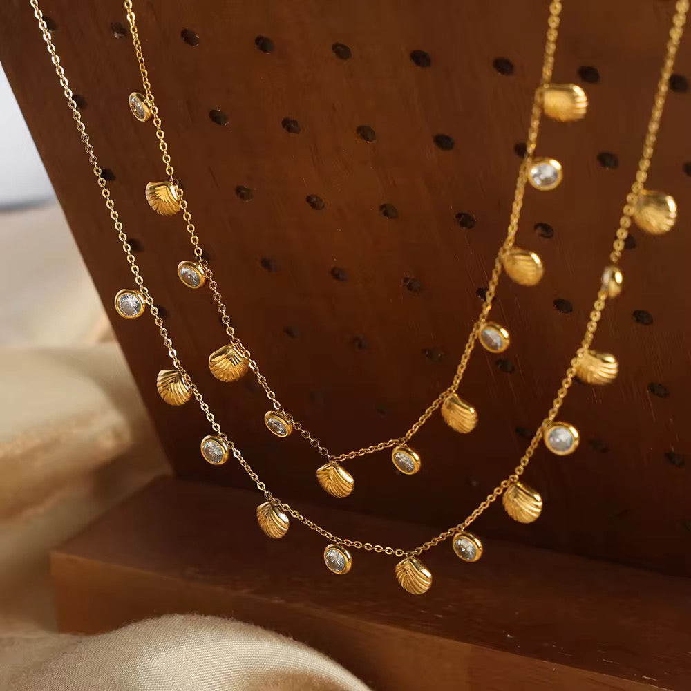 Dainty seashell charm necklace with gold finish and crystal accents, perfect for vacation or daily wear