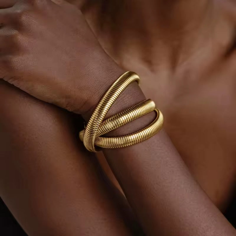 Stylish spiral gold bangle bracelet, trending statement accessory for women.